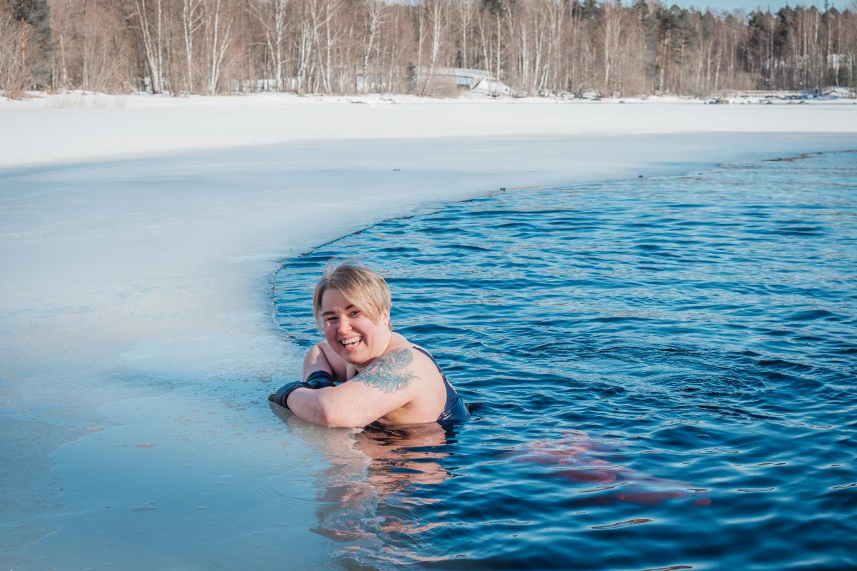 Nainen hymyilee avannon reunalla.