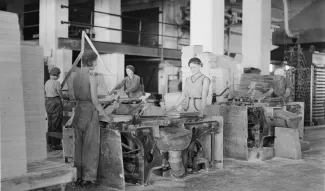 Vaneritehtaan sisäkuva jossa koneita ja työntekijöitä