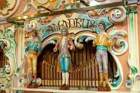 Koristeellinen kuva mekaanisesta soittimesta, jossa ihmishahmoja.