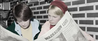 vanha valokuva lehteä lukevista ihmisistä.