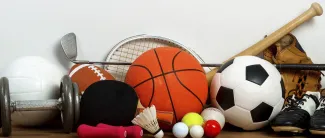 Erilaisia urheiluvälineitä, kuten palloja, mailoja, nappulakengät.