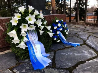 Seppeleitä sankarihautausmaalla. Kukat sinisiä ja valkoisia. Sinivalkoiset nauhat.