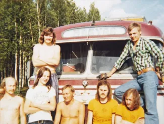 Kuvassa on Magyar-yhtye nojaamassa keikkabussiin.